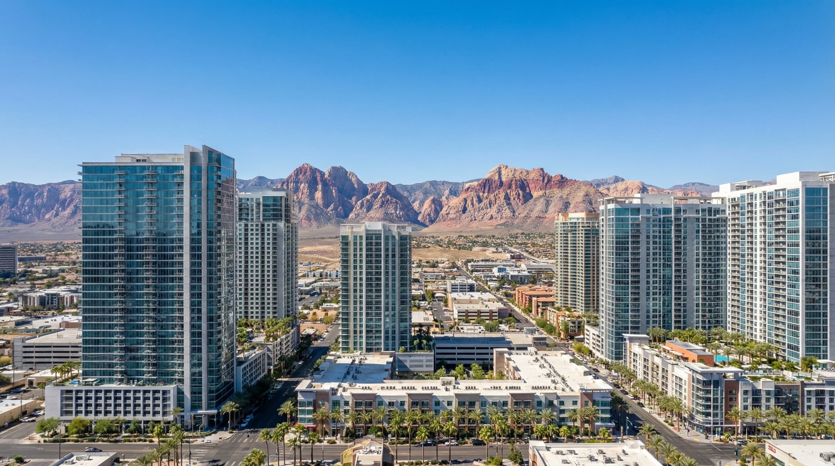 Las Vegas Nevada skyline at twilight with illuminated Strip resorts, desert mountains backdrop, and luxury high-rise residences