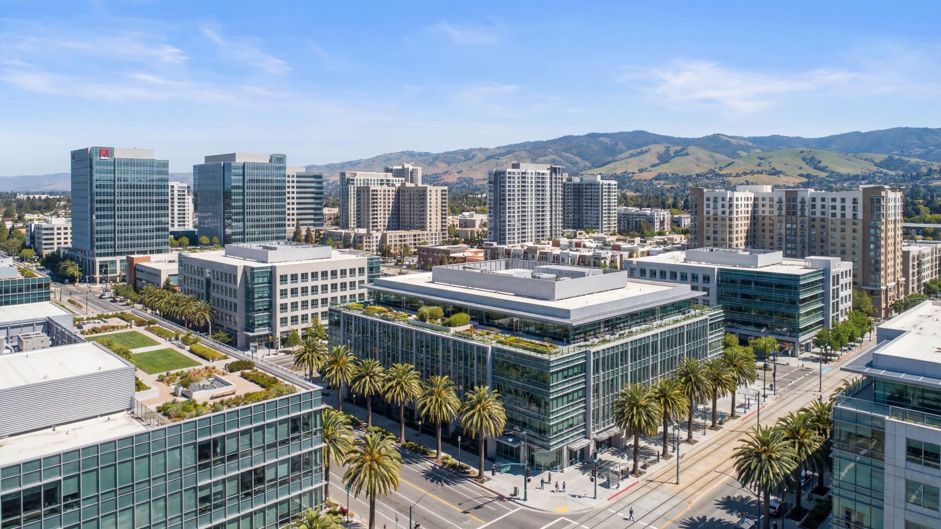 Modern Silicon Valley downtown San Jose cityscape with palm trees and Santa Cruz Mountains